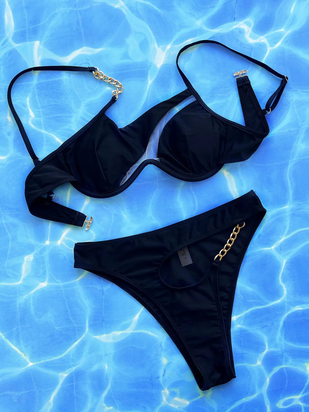Black women's two-piece bikini swimsuit with a hollow split design on a mannequin.