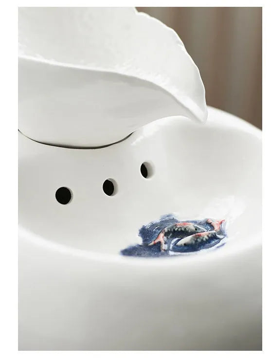 White ceramic automatic cat water dispenser with leaf design and US plug on a wooden floor