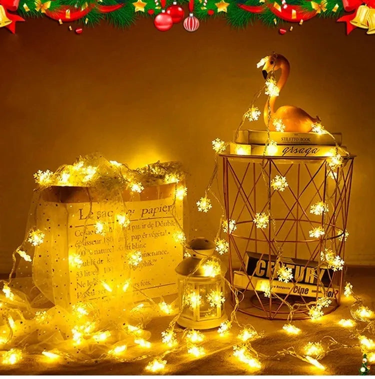 Battery powered LED snowflake string lights in warm white on a garden tree branch for Christmas decoration