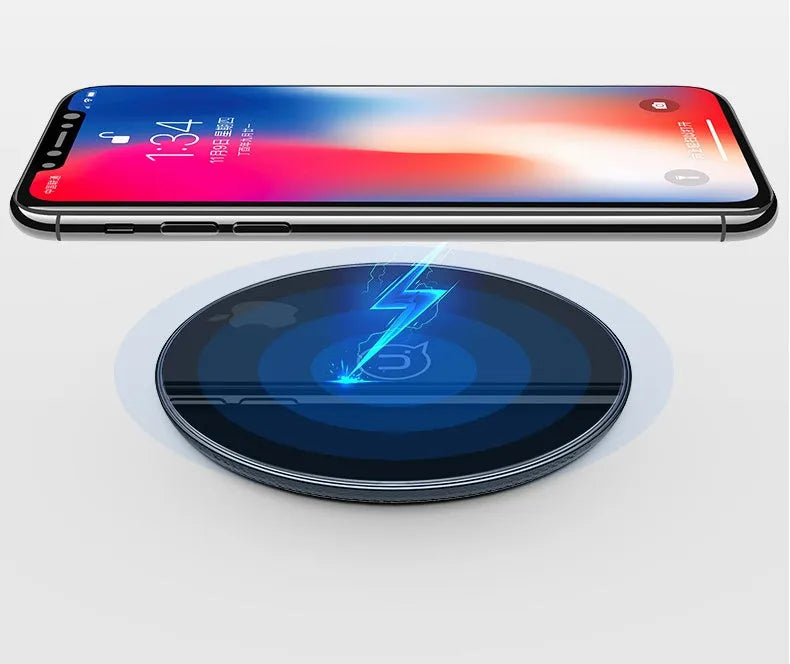 A black or white glass disc wireless charger on a table, showing its sleek design.