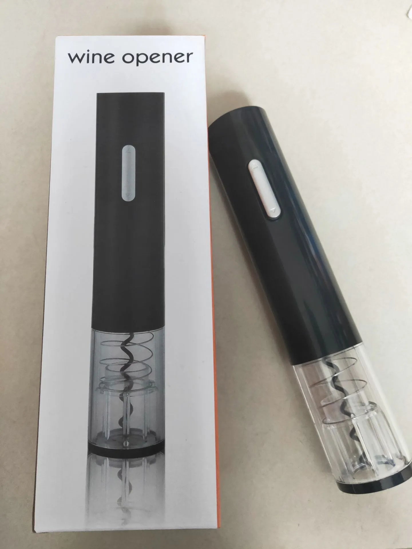 Black automatic electric wine bottle opener with foil cutter on a kitchen counter.