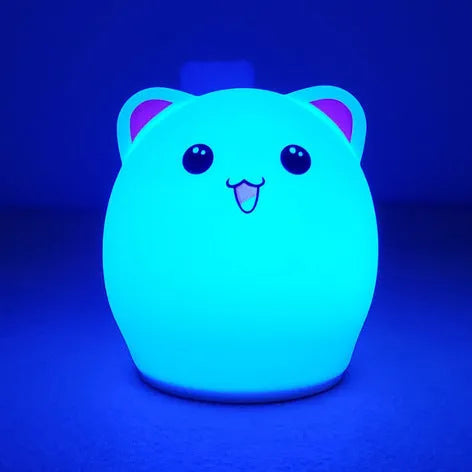 Cartoon silicone clapping night lamp in pink with USB charging cable on a bedside table