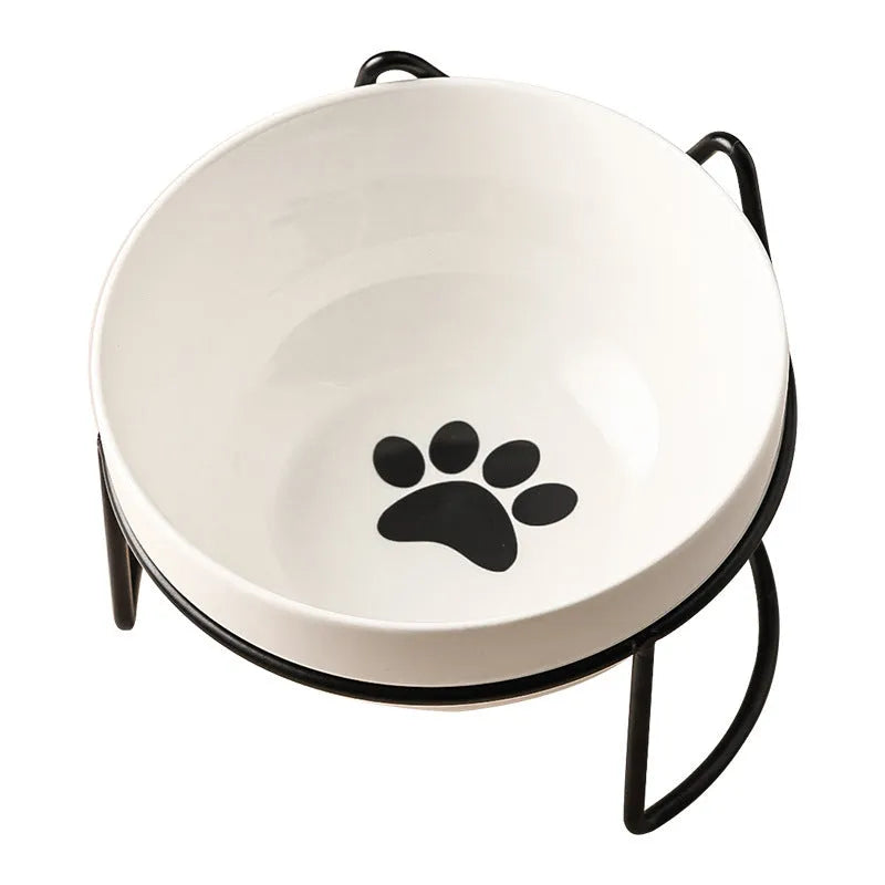 White ceramic cat bowl with cat footprint design on a black iron stand with cat ears.