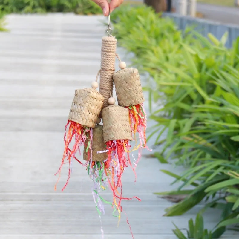 Wooden parrot chewing toy with colourful shredded paper decorations and sisal rope attachments