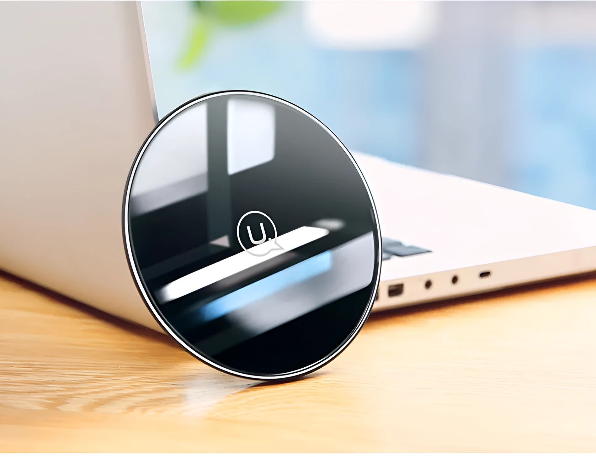 A black or white glass disc wireless charger on a table, showing its sleek design.