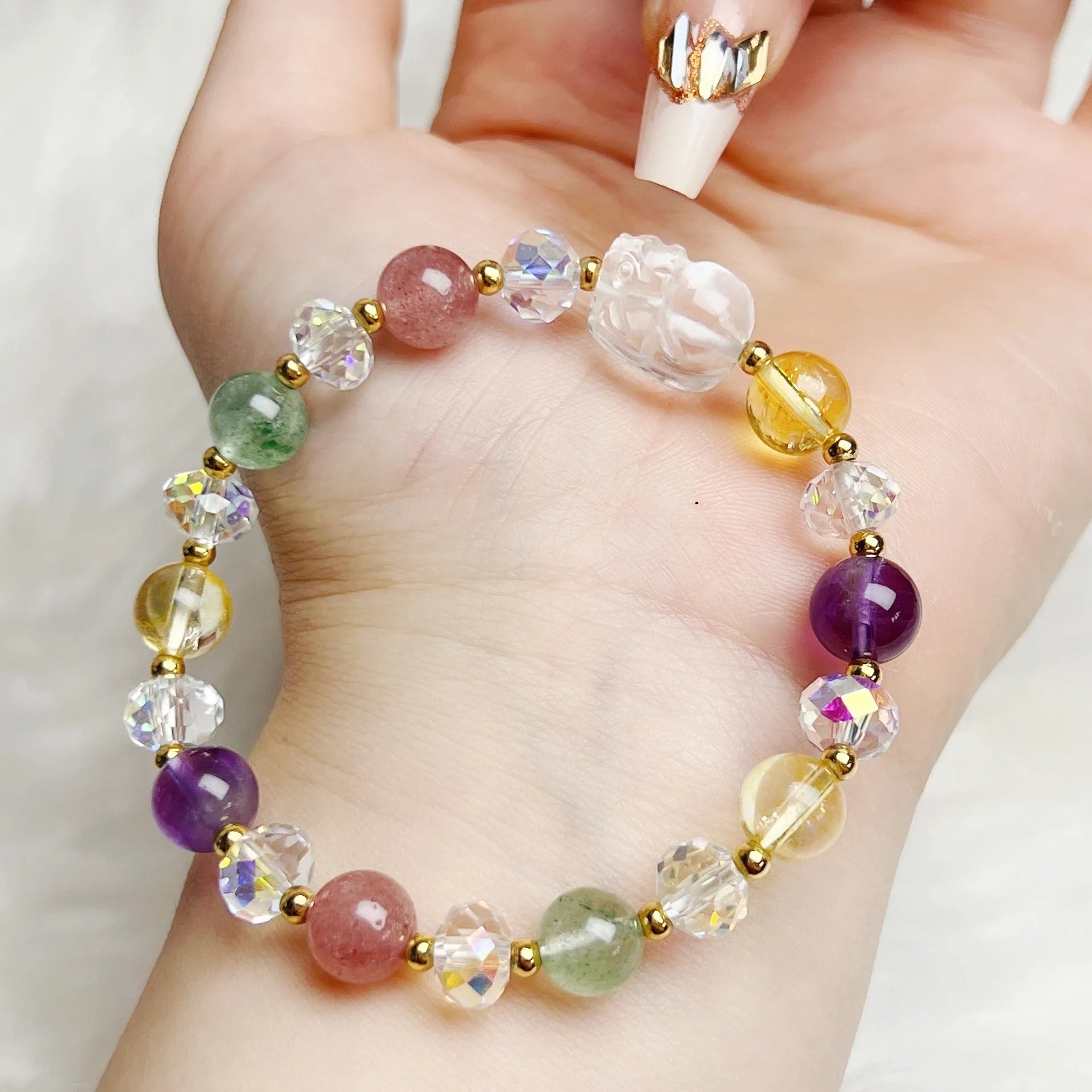 Close-up of a manually crafted crystal bracelet with a nine-tail fox centrepiece on a wrist.