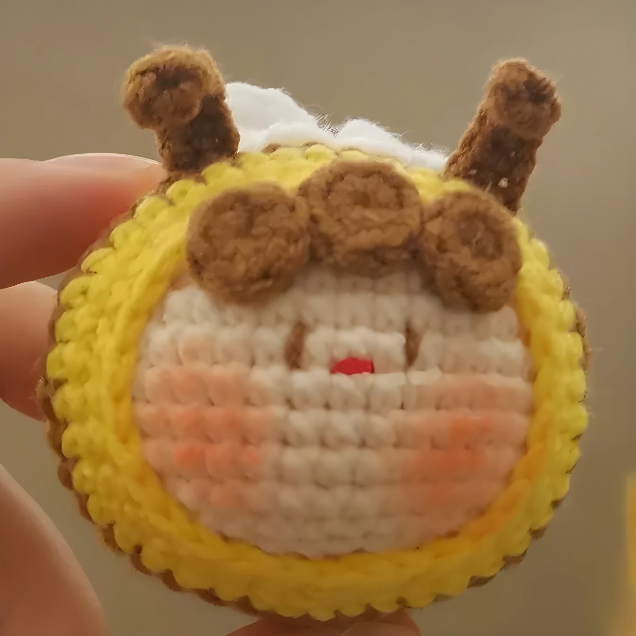 Handmade crocheted plush bee hive and bees accessory for woolen dolls on a white background.