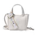 Genuine cattlehide leather retro crossbody bucket bag in black showing external slit pocket and sewing thread detail.