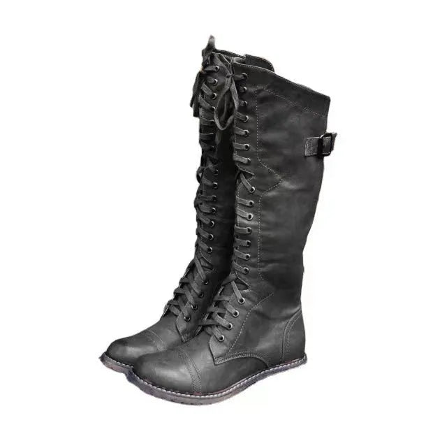 Black chunky heel high leg boots with a round toe and low heel on a plain background.