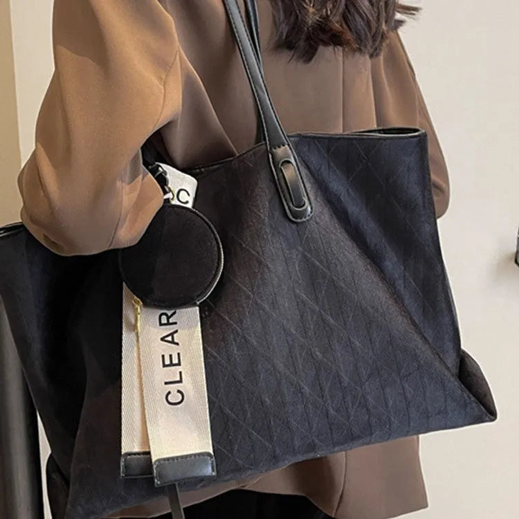 Large black polyester shoulder bag showing horizontal square shape and organisational pockets