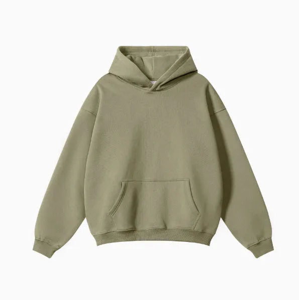 A man wearing a loose-fit, grey cotton terry hooded sweater with drop-shoulder sleeves.