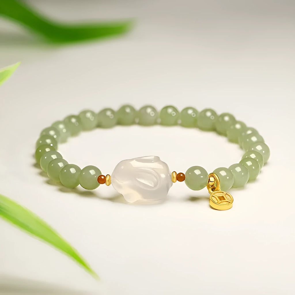 Close-up of a women's handmade bracelet with a detailed jade rabbit charm in a gift box.