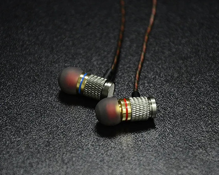 Black wired in-ear headphones with 3.5mm L-bend plug and silicone cable, showing TPE earplugs.
