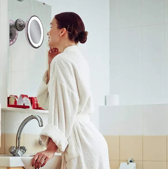 White 10x magnifying LED makeup mirror with gooseneck and suction base on a countertop