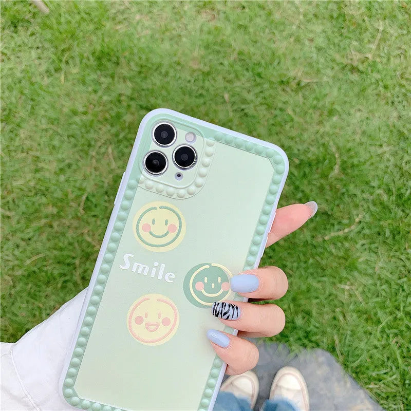 Green iPhone case with geometric smiley face designs and polka dot frames on flexible TPU material