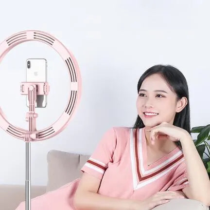 Portable 290mm LED selfie ring light in black on table, showing centre phone holder and adjustable brightness button