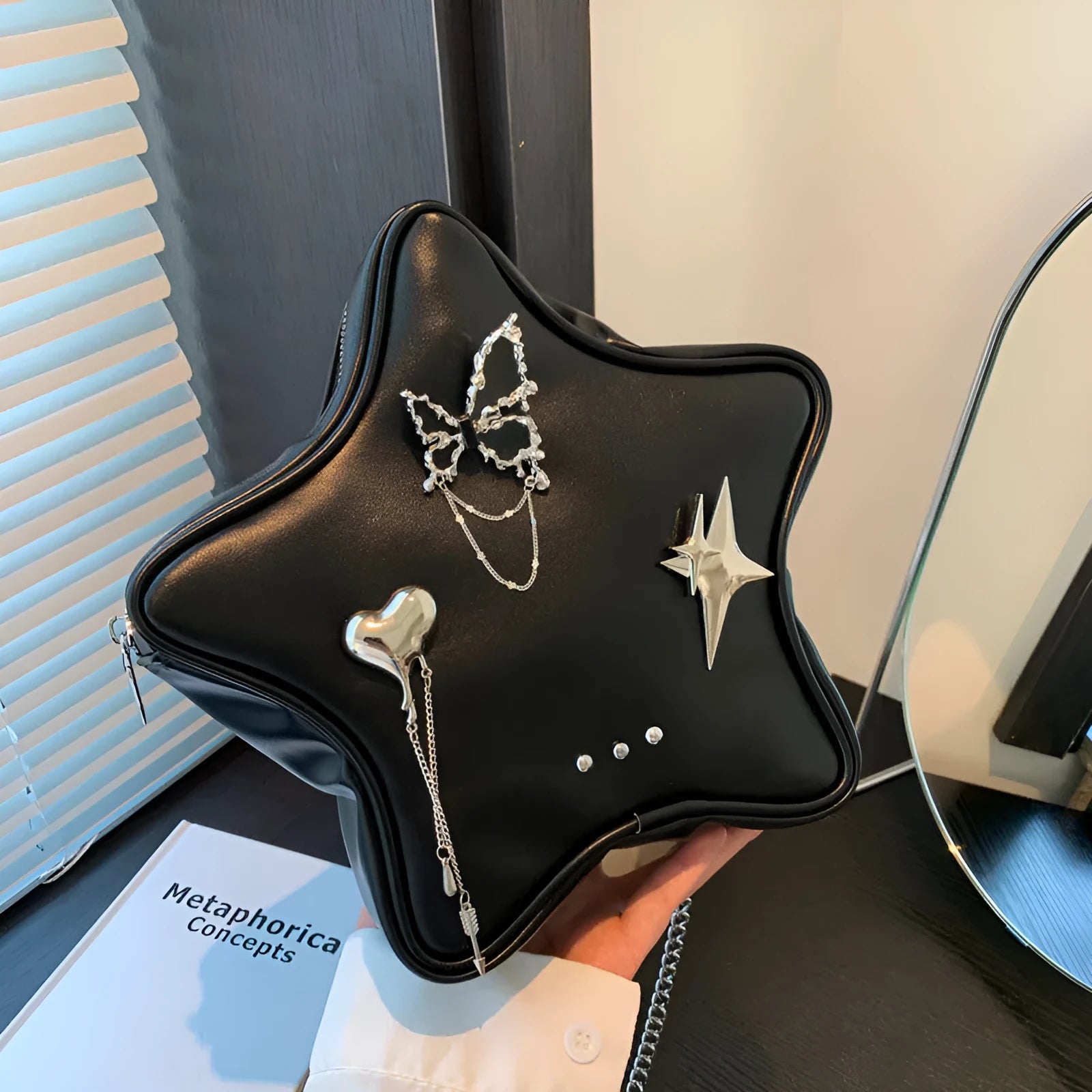 Black PU leather backpack with metal chain trim and star pendant on strap