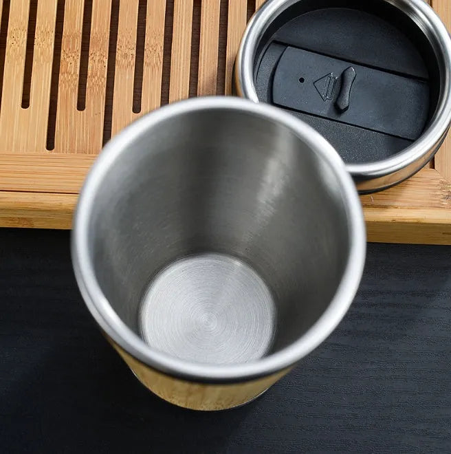 Bamboo coffee cup with double wall insulation, leak-proof lid, and non-slip foam pad on a table