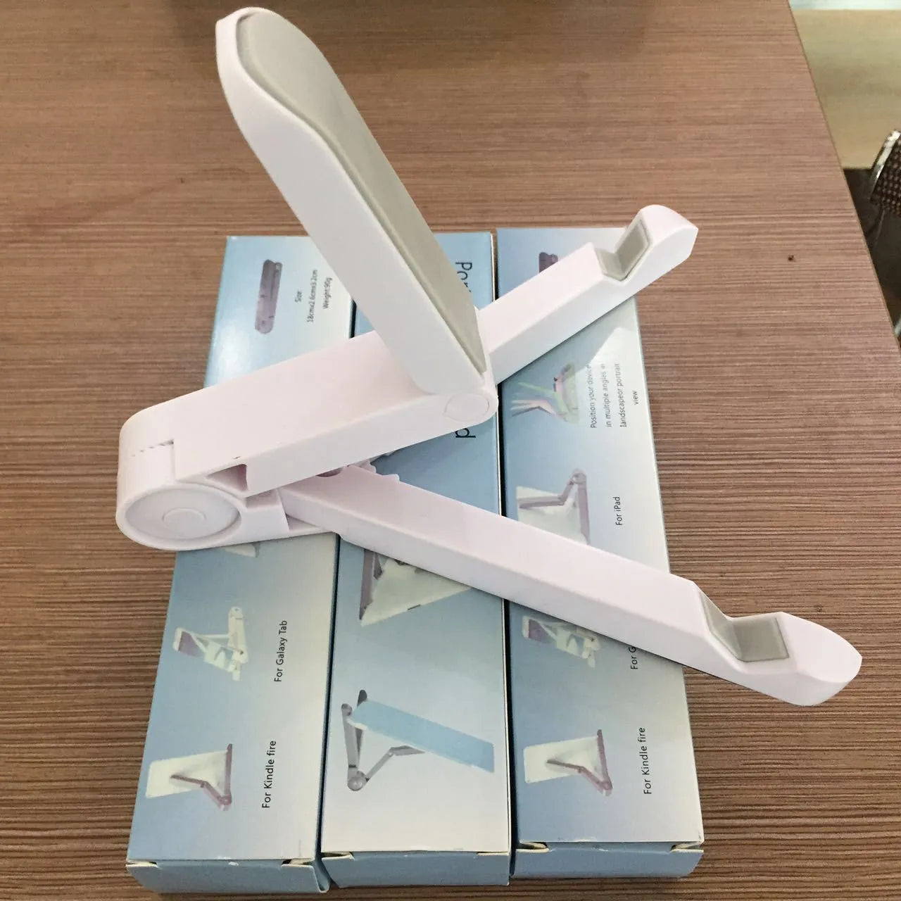 Black foldable tablet holder showing adjustable angles and rubber surface for device protection