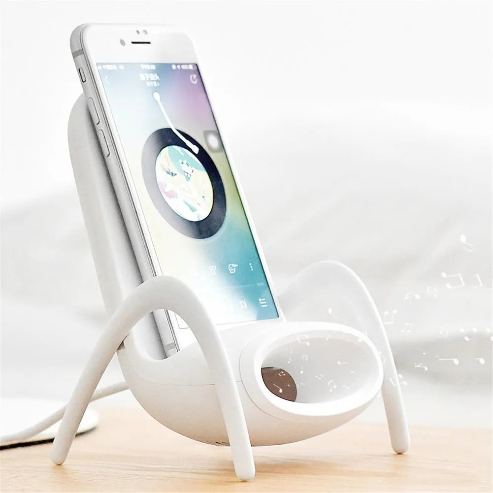 White mini chair-shaped wireless charging stand holding a mobile phone at an angle.