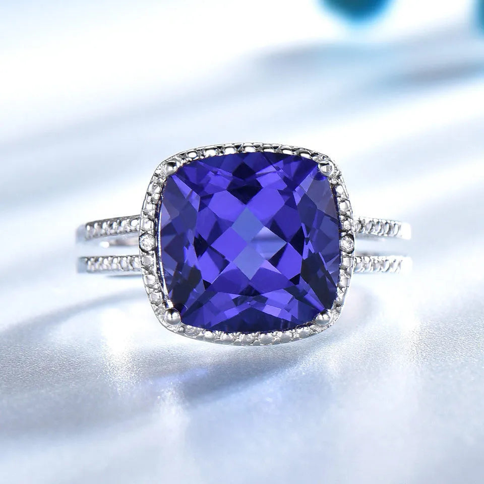 A women's sterling silver ring with a blue Tanzanite gemstone on a silver band.