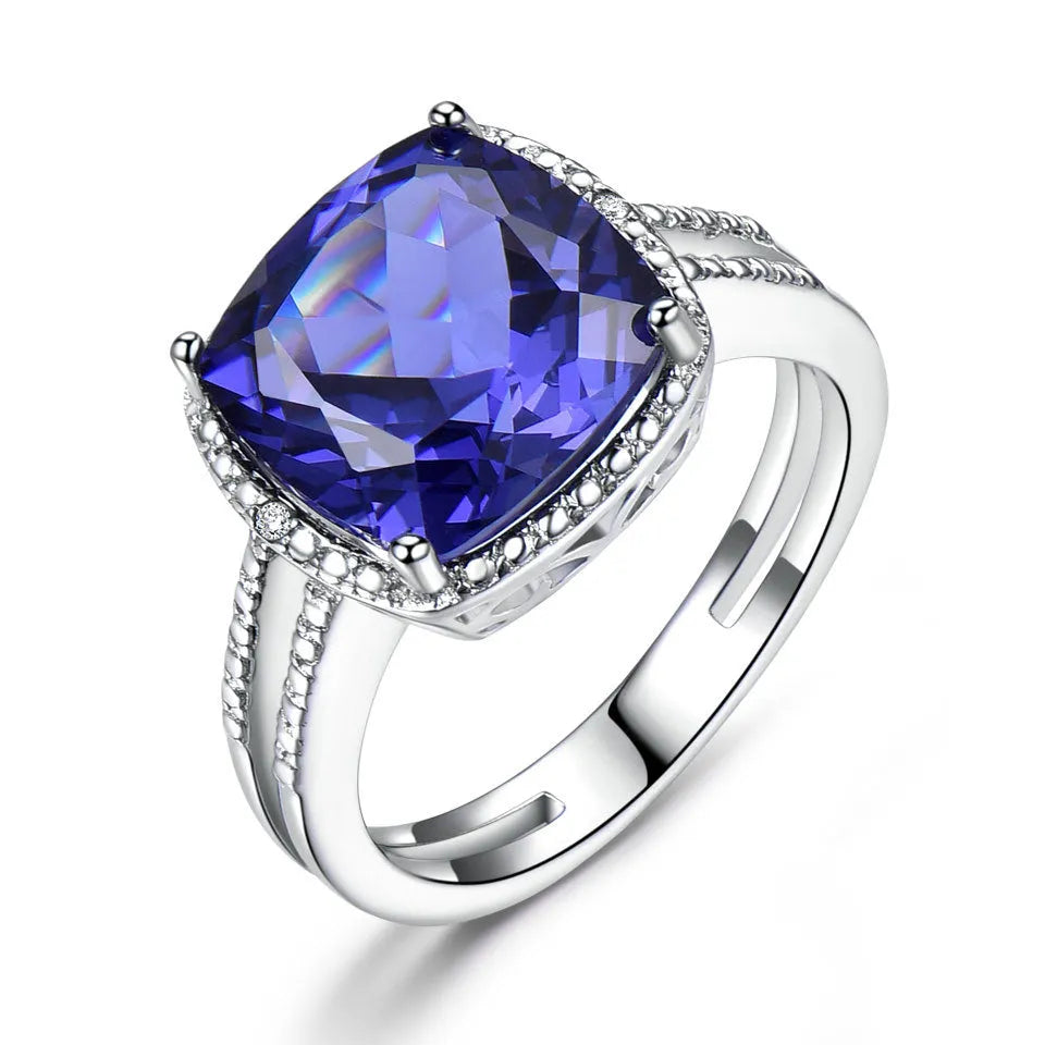 A women's sterling silver ring with a blue Tanzanite gemstone on a silver band.
