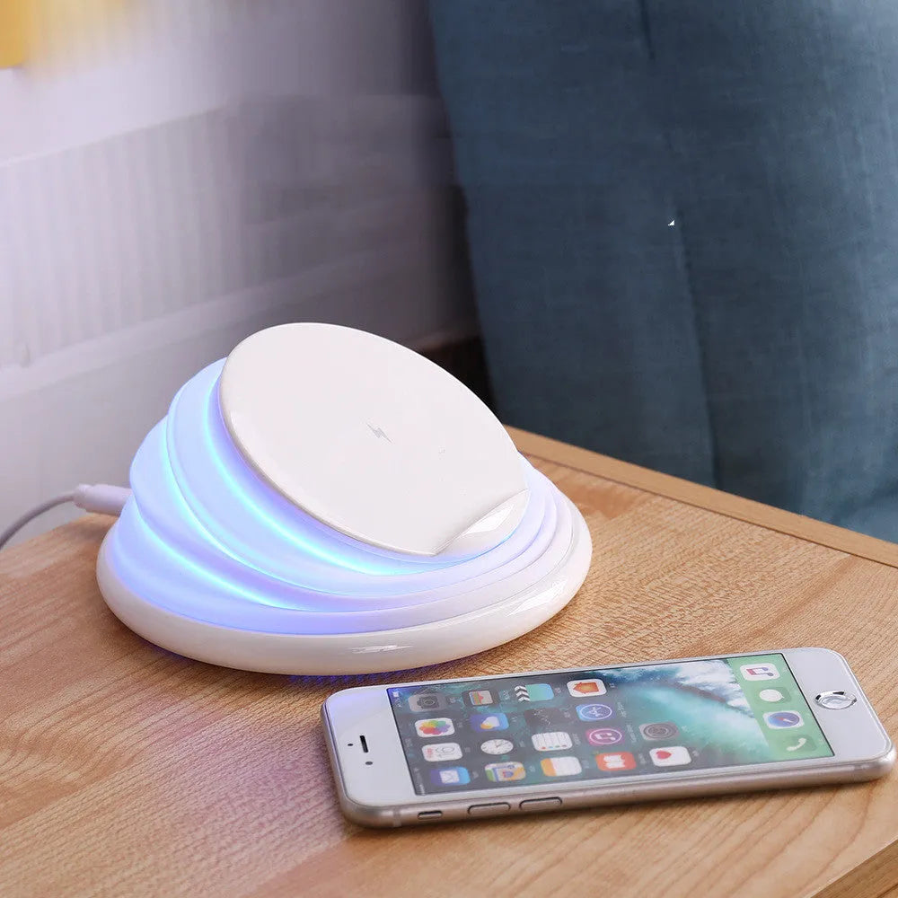 Grey wireless charger pad with silicone surface on a desk, 138mm square shape