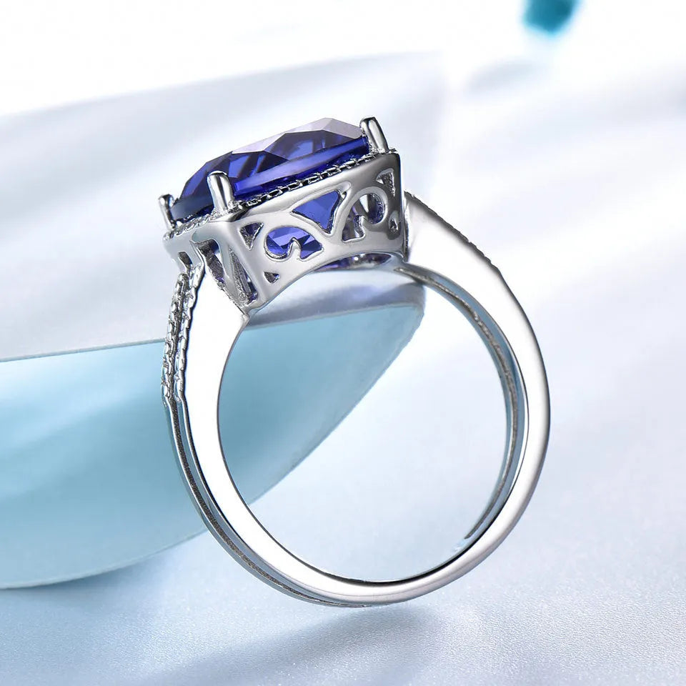 A women's sterling silver ring with a blue Tanzanite gemstone on a silver band.