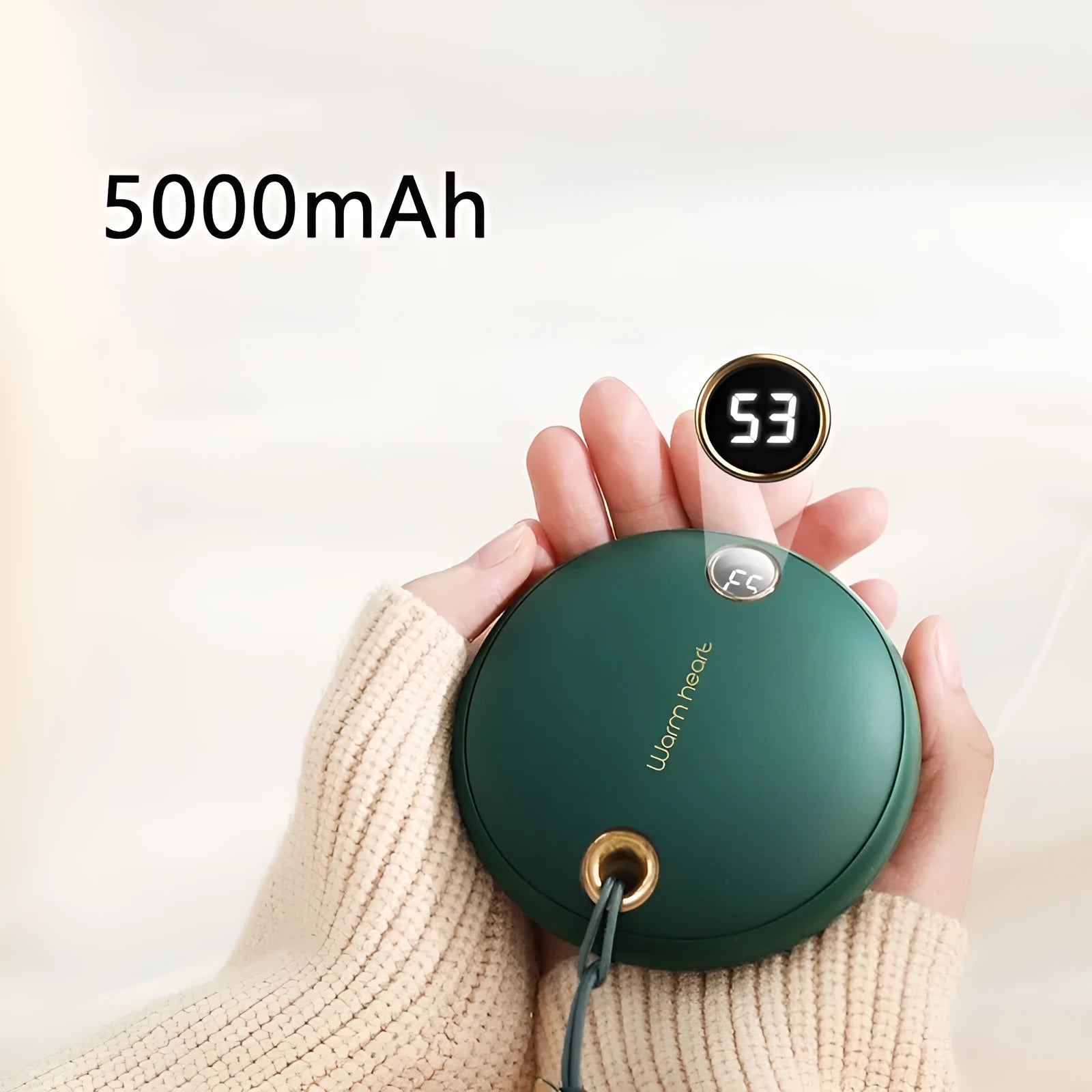 Green hand warmer power bank with digital display showing charge level, next to a charging cable.