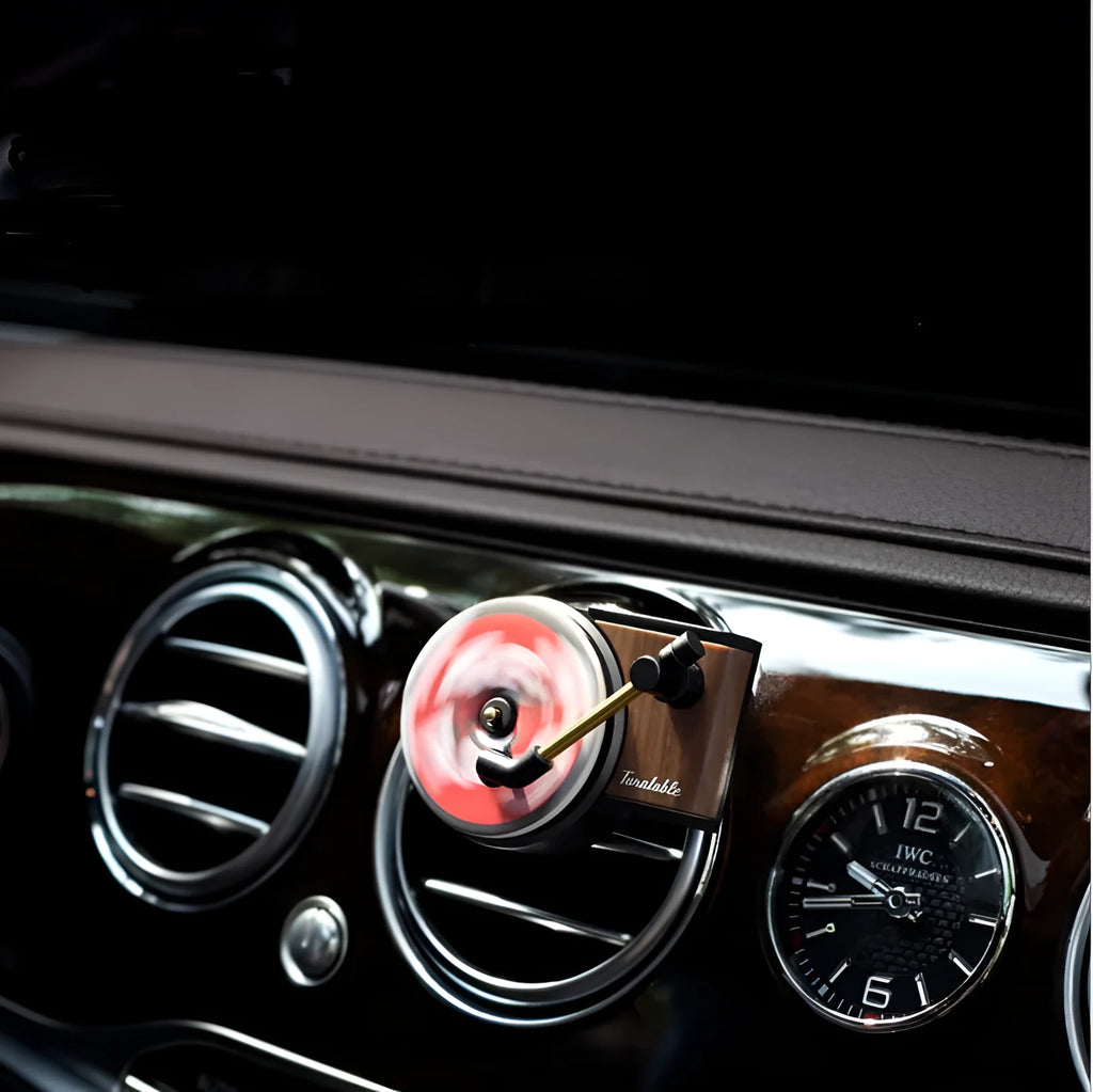 Black turntable car aroma diffuser with ocean scent fragrance tablet on car dashboard