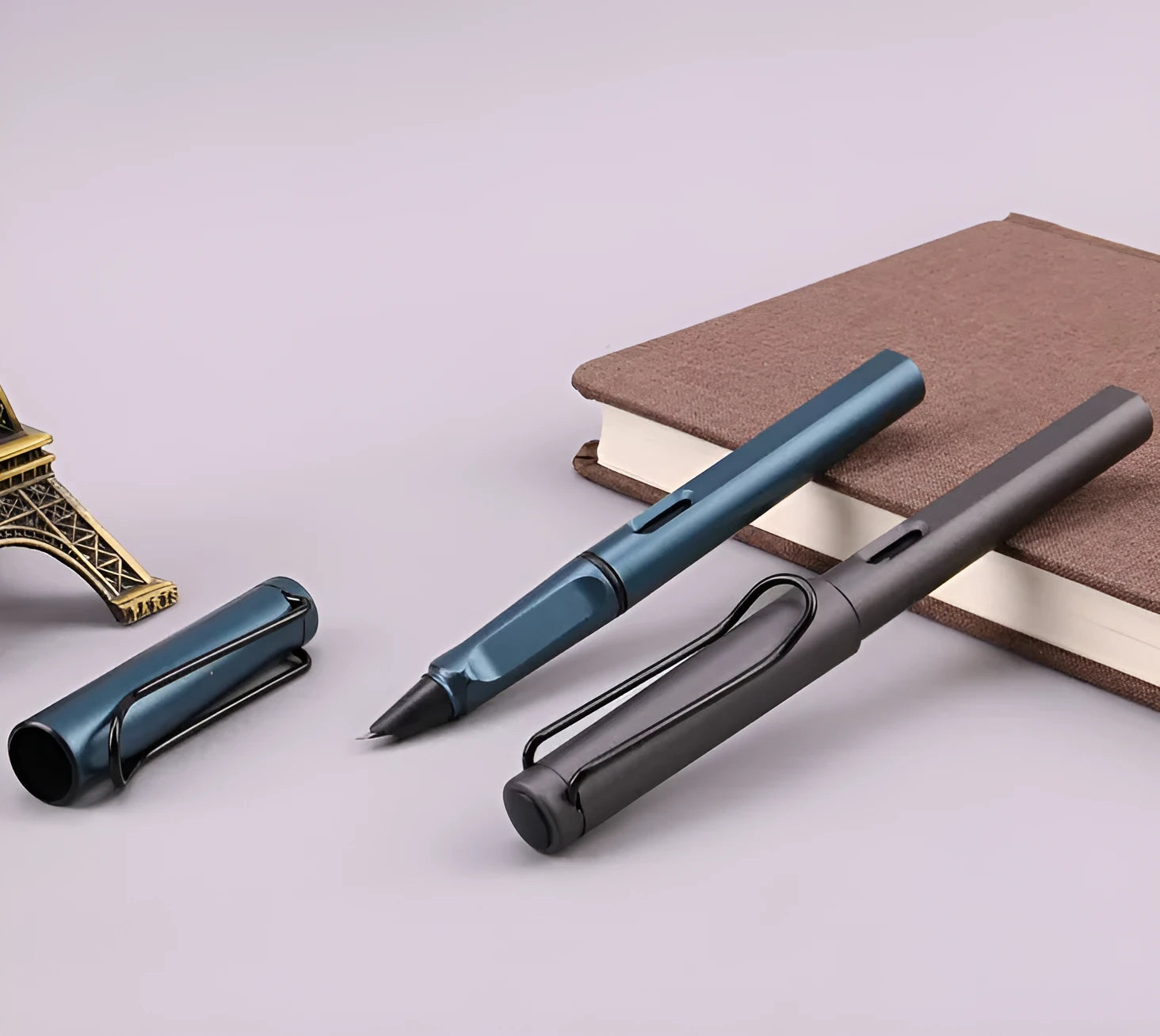 Close-up of a frosted texture fountain pen with a stainless steel nib, shown next to black and blue ink cartridges.
