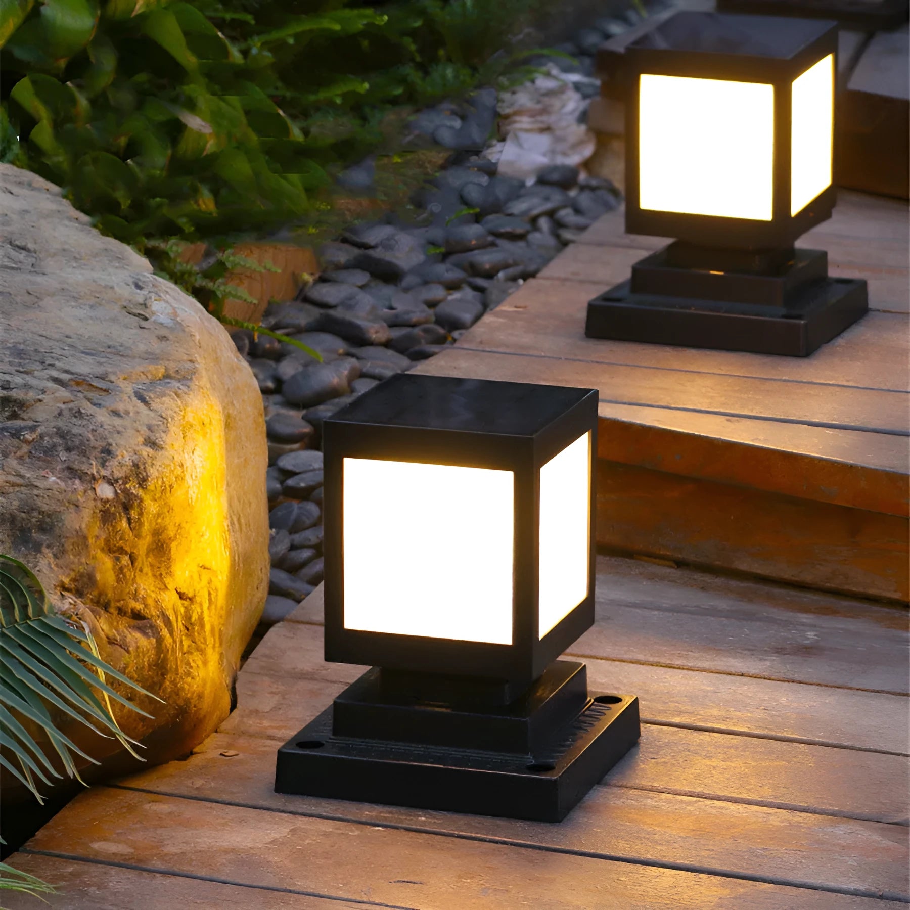 Set of solar-powered garden lights with LED illumination staked along a garden path at dusk