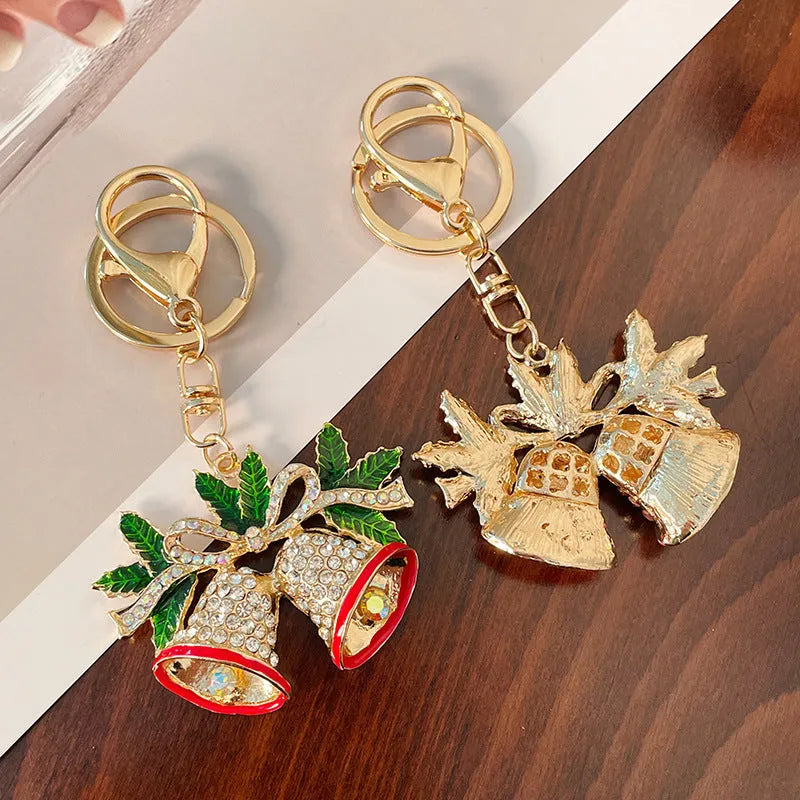 Diamond studded metal Christmas bell keychain in European style on a white background