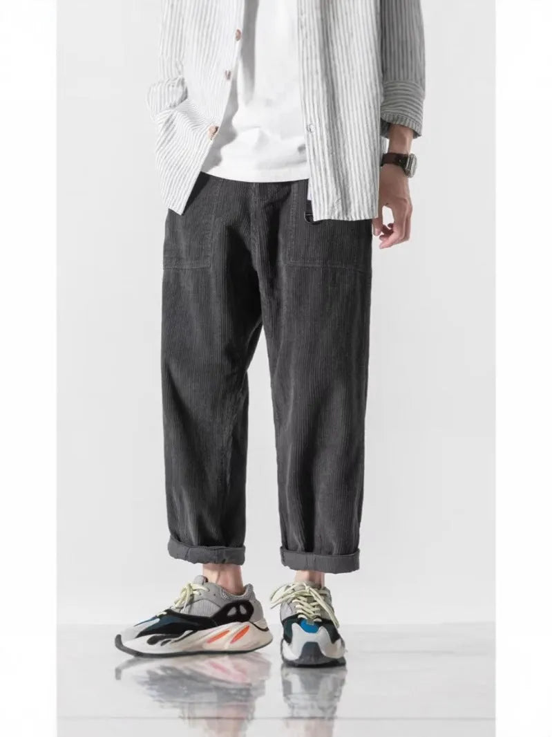 Man wearing loose straight tapered trousers in dark grey, showcasing the straight leg and relaxed fit.