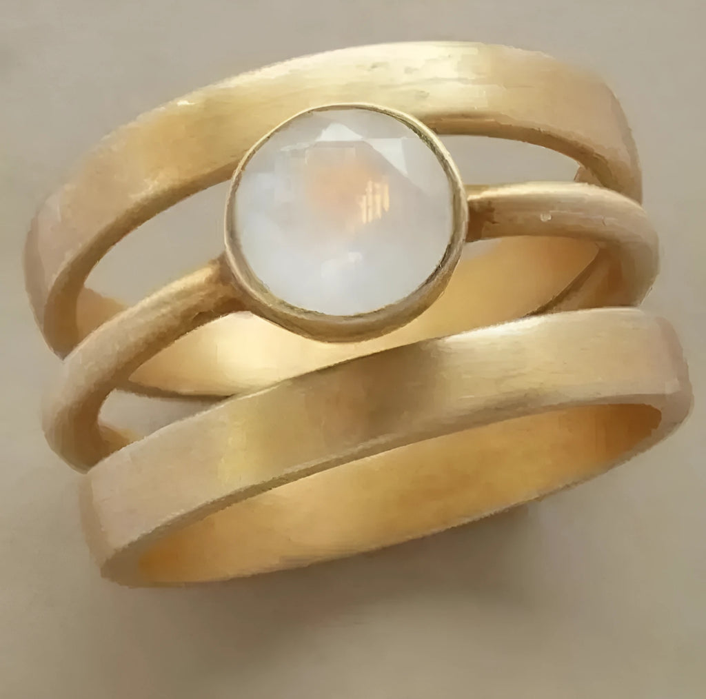 Gold-coloured geometric titanium steel ring with a micro-inlaid white chalcedony stone.