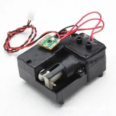 Black remote control tank model smoke box accessory with LED light on a model chassis.