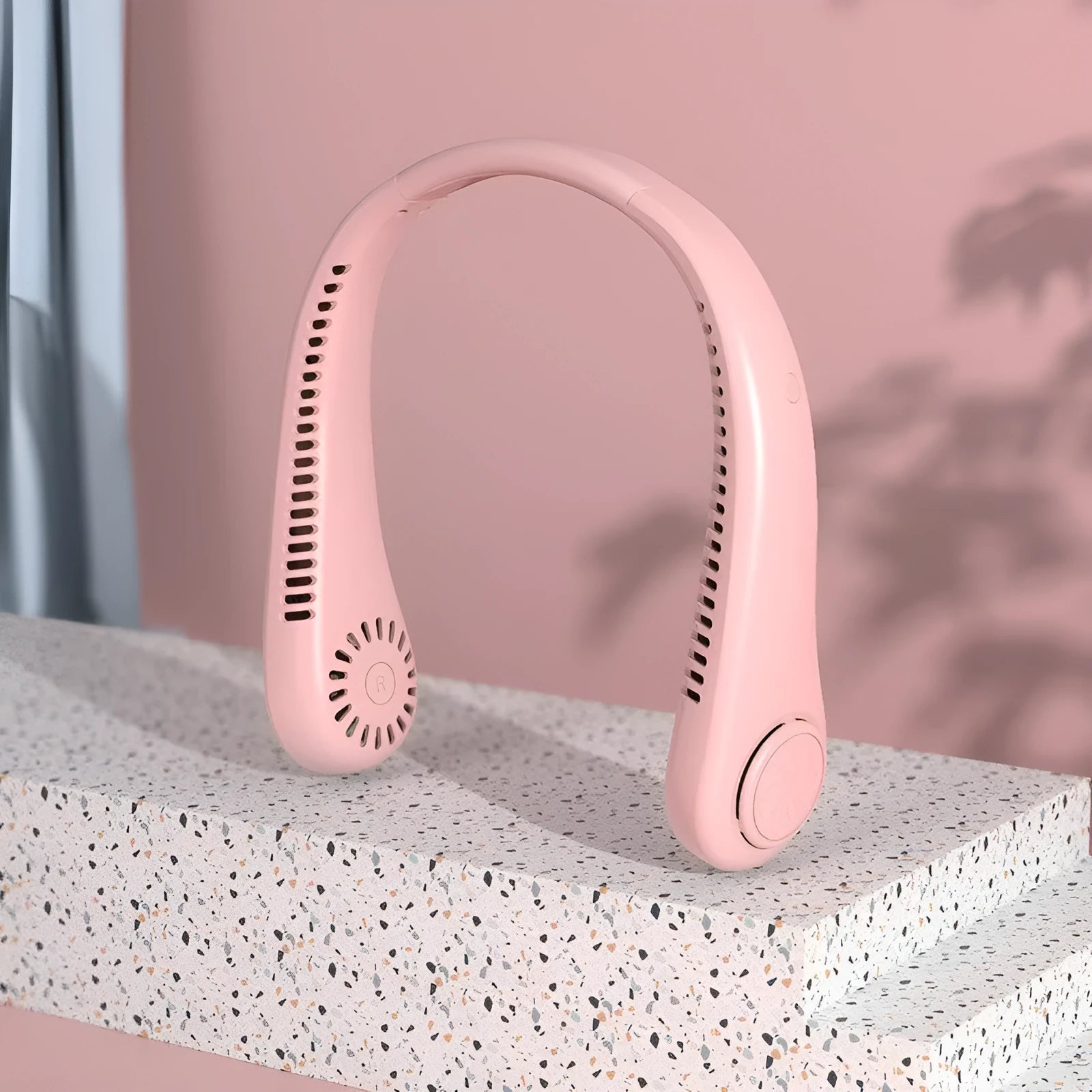 Pink bladeless neck fan being worn, showing adjustable neckband and air outlet.