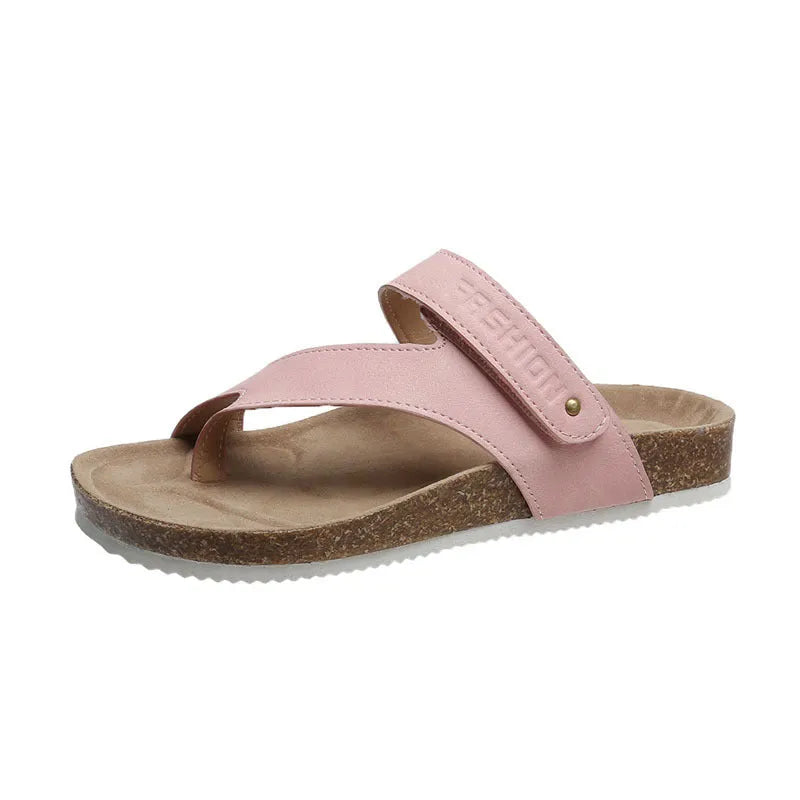 Flat toe ring flip-flops with a thick foam sole in a solid blue colour on a sandy beach.