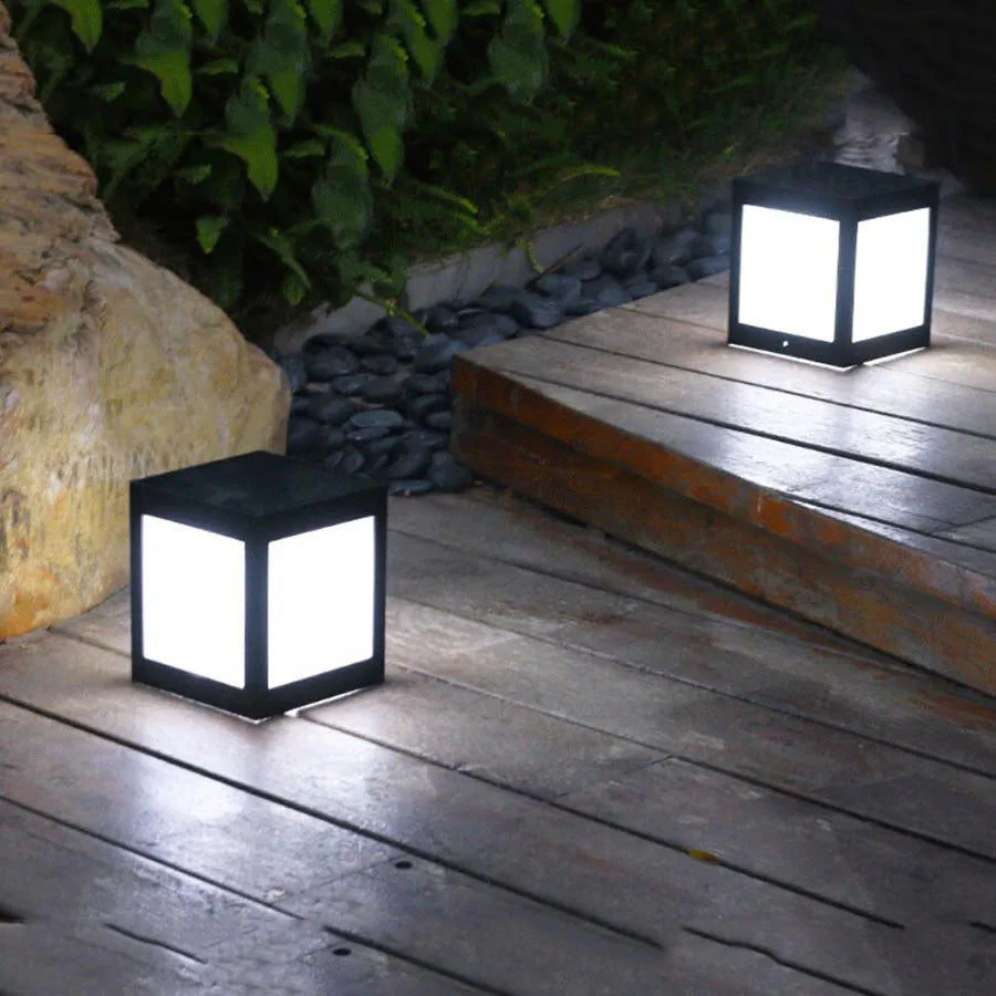 Set of solar-powered garden lights with LED illumination staked along a garden path at dusk