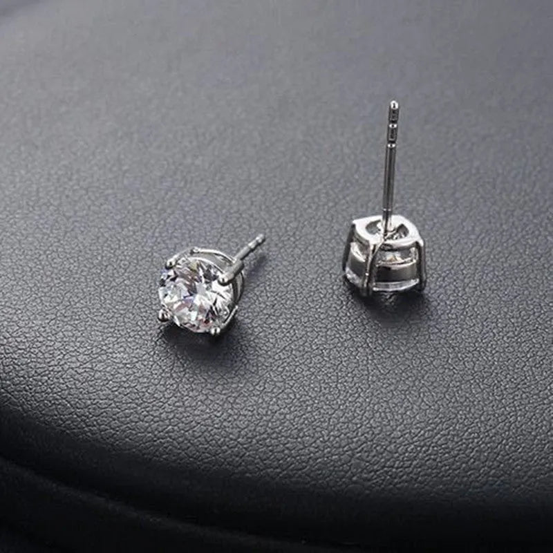 Pair of 925 sterling silver stud earrings with zircon stone detail on a plain background