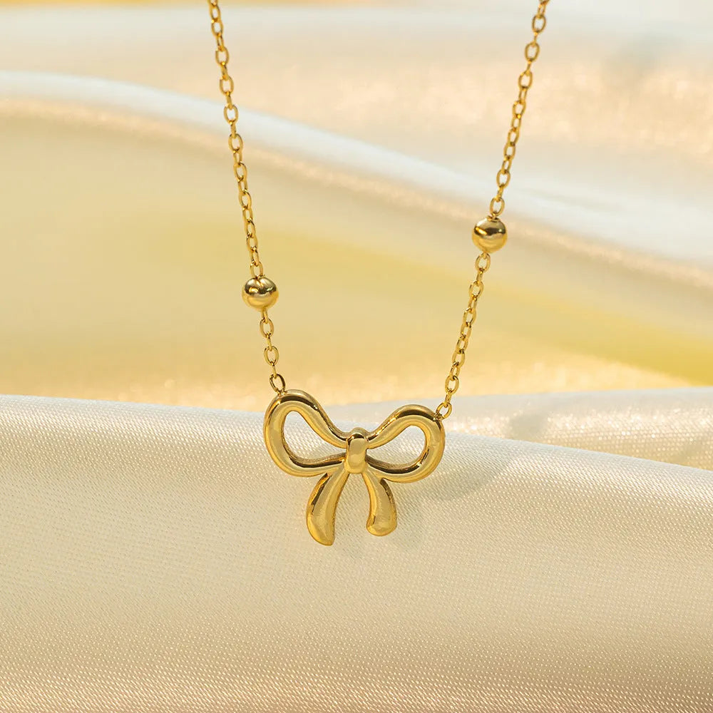 Gold electroplated titanium steel necklace with bow design and cross chain links