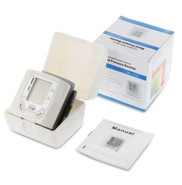 Grey portable wrist blood pressure monitor with digital display on a wrist.