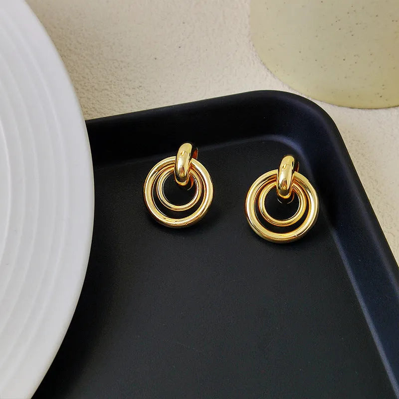 Geometric round ring earrings with irregular shape in gold electroplated finish on mixed material