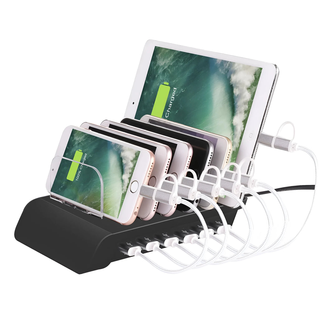 Six-port USB mobile phone charging stand in silver with multiple phones and tablets inserted, on a wooden desk