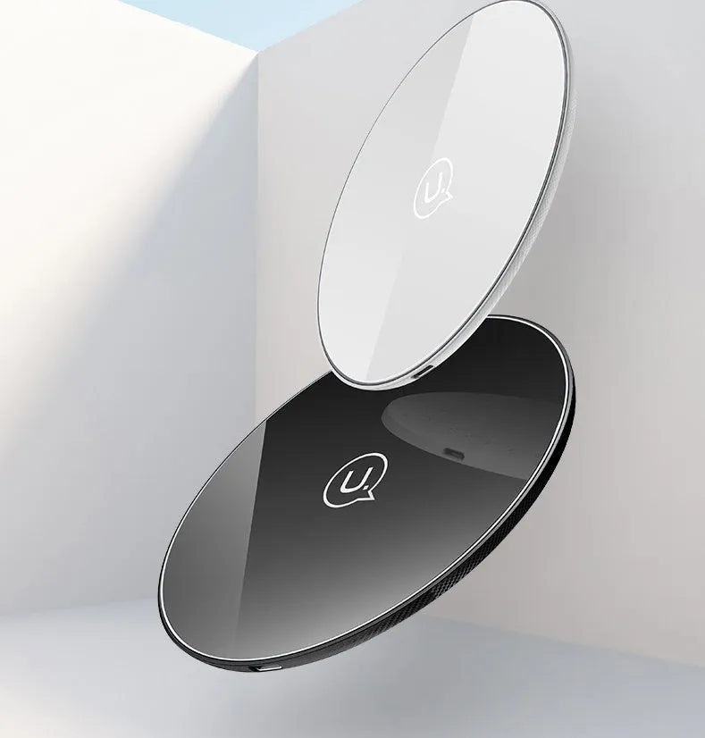 A black or white glass disc wireless charger on a table, showing its sleek design.