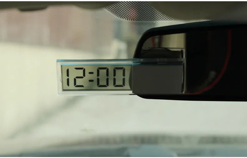 Dot matrix LCD car clock with suction cup on dashboard showing time and date