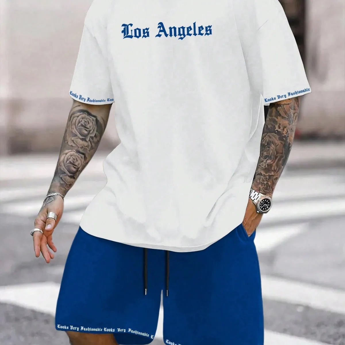Man wearing a printed short-sleeve top and matching shorts from a sports style suit set.