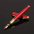 Red and black metal ballpoint pen with a 0.5mm stainless steel nib on a notepad.