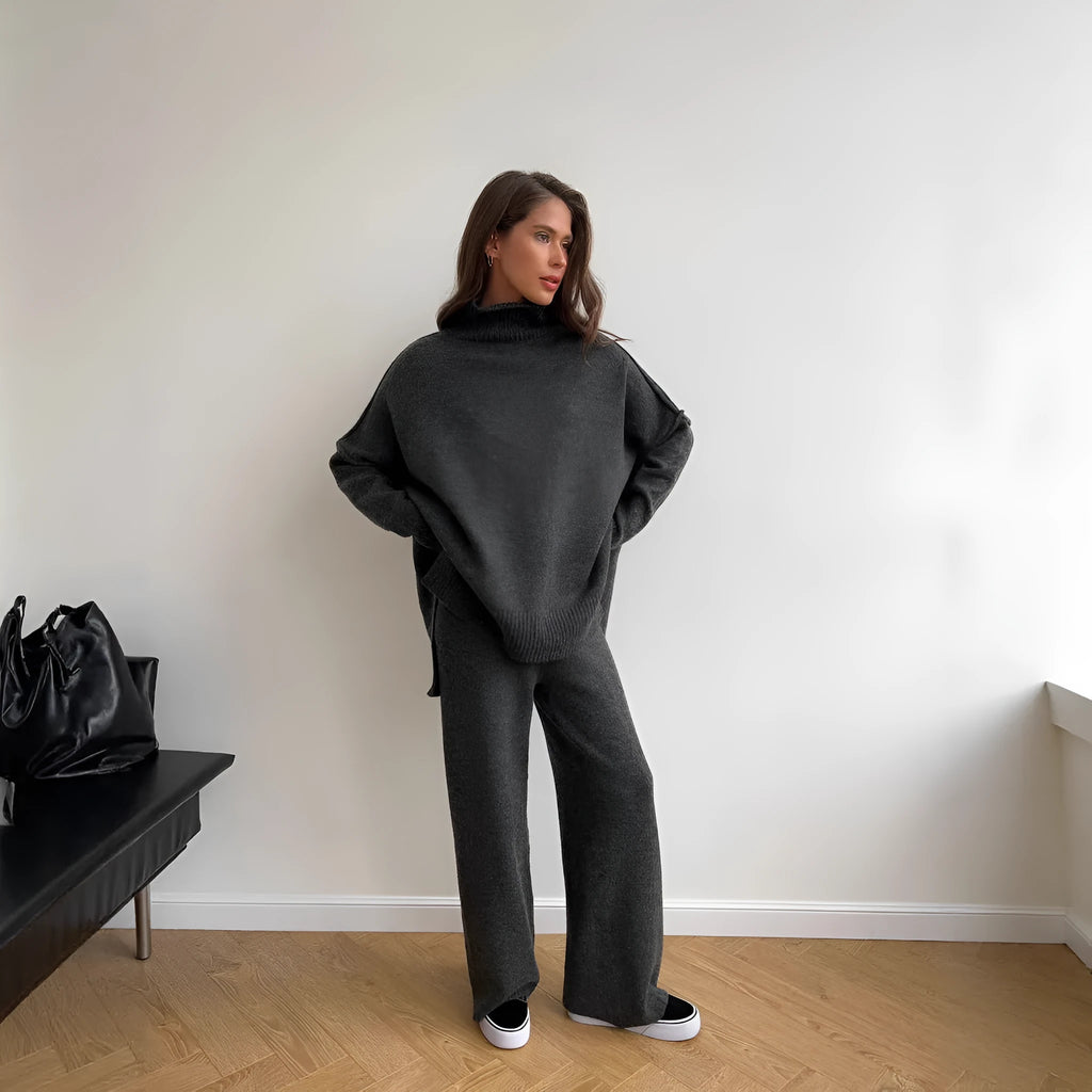 Women's dark grey side-slit knit top and matching trousers, a two-piece acrylic suit set laid flat.