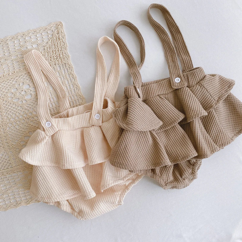 Baby romper with triangle climb style in cotton fabric showing apricot, coffee, floral and check colour options